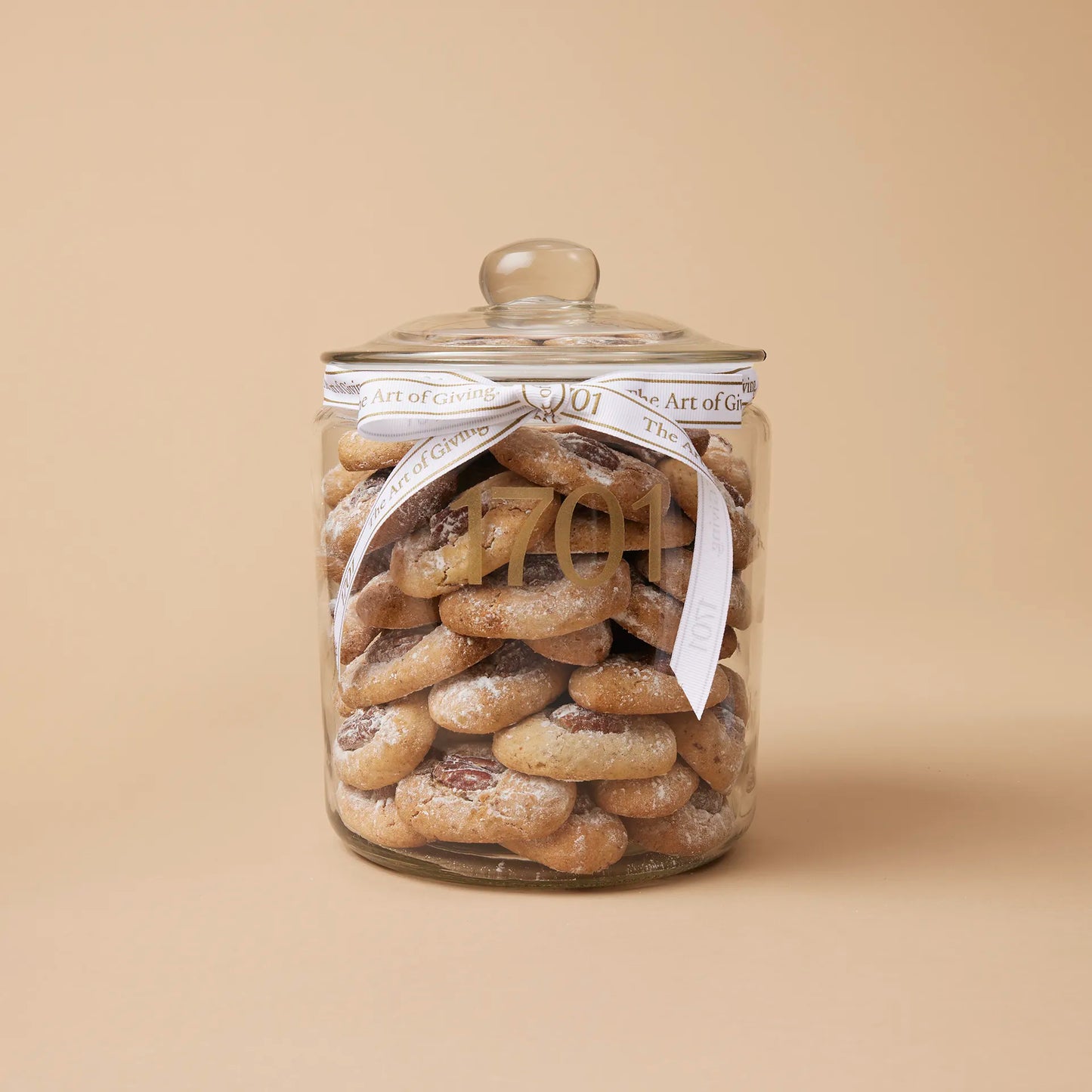A 1kg glass jar of handmade biscuits with pecan nuts, presented in a glass jar with a hand-tied signature ribbon on a warm background, with the product label visible on the front of the jar. The biscuits are SANHA Halaal approved, making them a perfect gift idea for anyone who appreciates high-quality biscuits made with care.