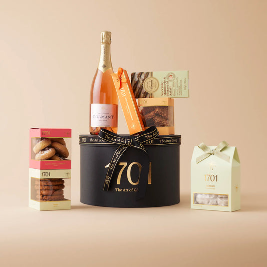 A gift box with South Africa's Best Bubbles - Rosé NV. The box includes a box of handcrafted honey nougat, a nougat bar, a curated selection of biscuits, an imported Italian chocolate and a bottle of Colmant MCC Non-Reserve or Rosé. Presented in a signature hat box, it's perfect for a celebration or an intimate moment.