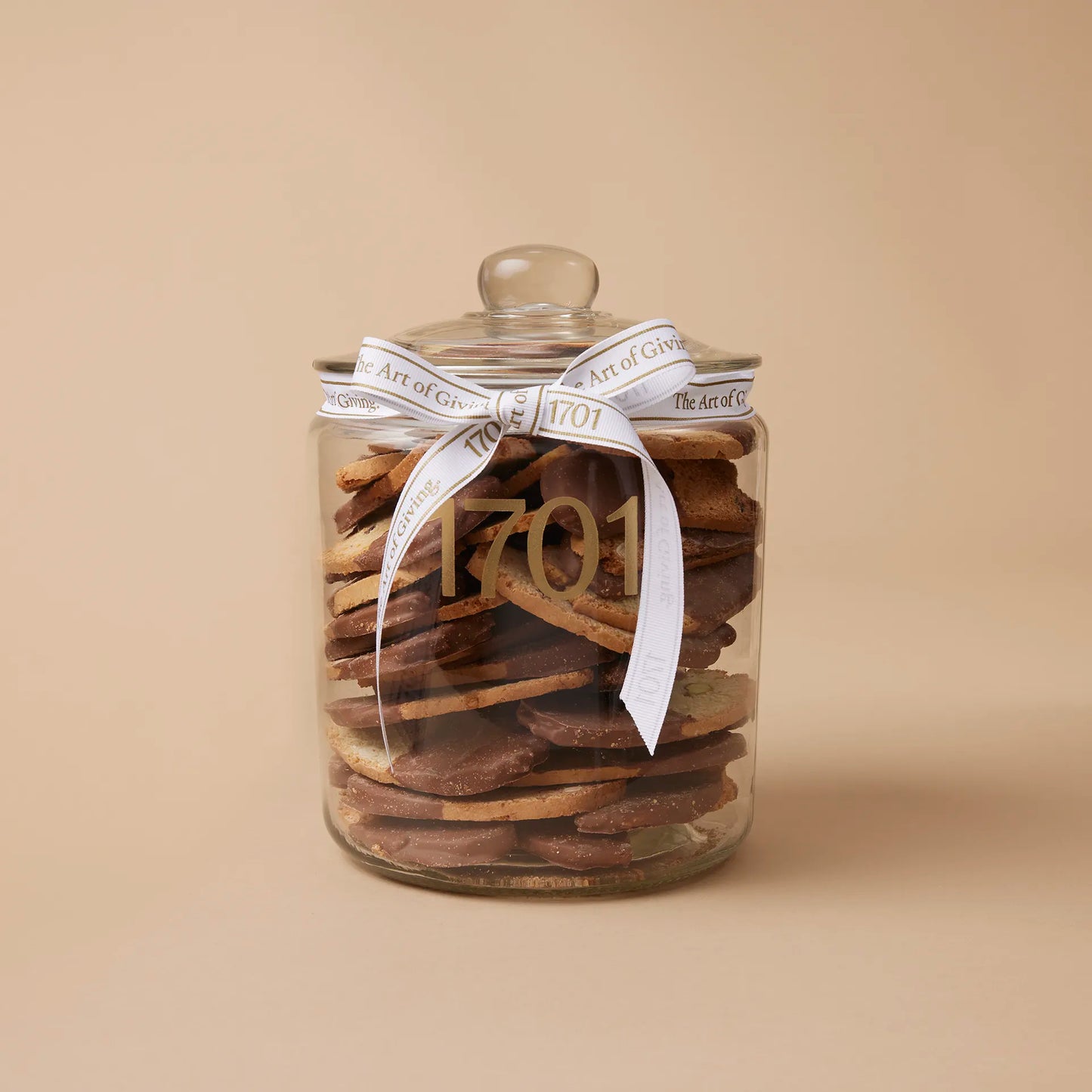 "Belgian Milk Chocolate Dipped Italian Biscotti" gift jar featuring a 1kg glass jar of handmade biscuits dipped in Belgian milk chocolate. The biscuits are presented in a glass jar with a hand-tied signature ribbon on a warm background, with the product label visible on the front of the jar. The biscuits are SANHA Halaal approved, making them a perfect gift idea for anyone who appreciates high-quality biscuits made with care.