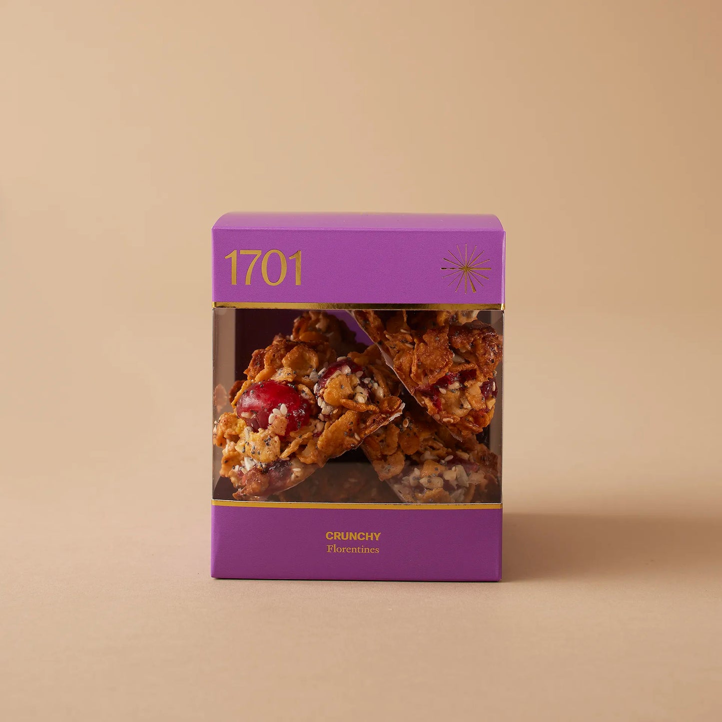 The Crunchy Florentines Box (200g) is presented on a warm background. The boxfeatures a purple and gold design. It contains 200g of handmade biscuits that are SANHA Halaal approved, including crunchy florentine bicuits. This box of delicious biscuits is the perfect thoughtful gift for someone close to you or a great opportunity to spoil yourself and your family.