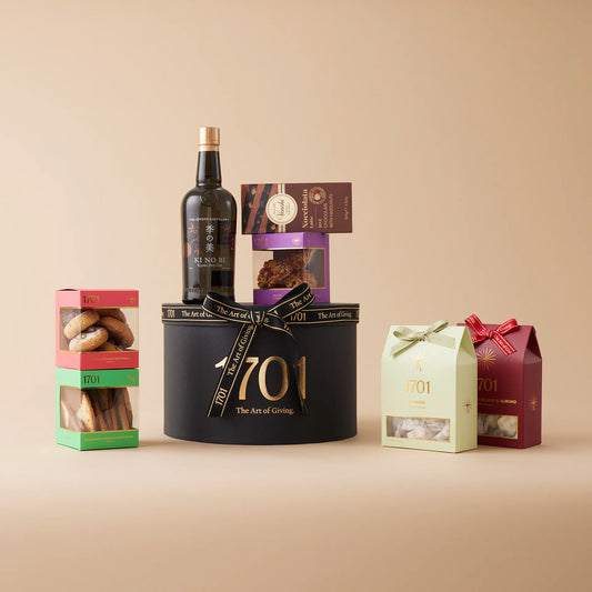 A gift box featuring a bottle of Ki No Bi Gin, along with two boxes of handcrafted honey nougat, a selection of biscuits, and a slab of chocolate. Perfect for gin enthusiasts and those looking to indulge in something luxurious.